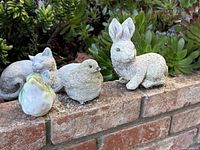 Group shot of rabbit and two birds on brick ledge