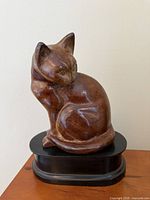 front left view of brown cat sculpture on black pedestal
