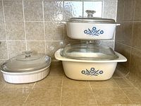 Front view of all three casseroles stacked and side by side with lids