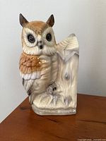 Front view of glazed ceramic great horned owl on stump