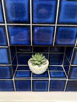 Overview of faux succulent seated in decorative ceramic planter