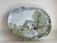 Full view of oval hand-painted platter on stand