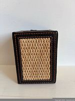 Front view showing woven panel framed by leather with stitching