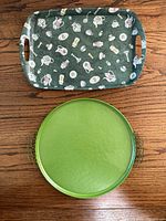 Both trays overview, round green enamel tray below, patterned rectangular tray above