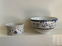 Side-by-side view of both porcelain pieces showing size difference and exterior patterns