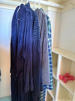 Four robes hanging on hangers showing full set and variety