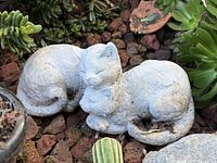 Top view of the two-cat cast-stone sculpture in garden setting