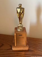 Front view of trophy on wooden base showing plaque