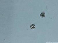 Both loose round brilliant diamonds on neutral background