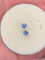 top view of two blue sapphire studs on foam pad
