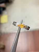 Top view of sterling silver ring with yellow centre and side sapphires