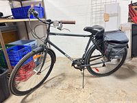 Full view of Annex grey commuter bicycle with pannier bags and kickstand