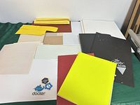 Overall lot view: notebooks, sketchpad, loose paper, envelopes, sticker sheet