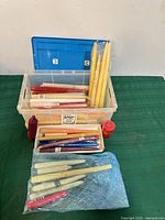 Plastic bin holding assorted taper candles in various colours and packaging