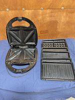 Open appliance with sandwich plates installed, additional plates alongside