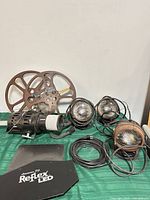 Group shot of three lights, two film reels, Reflex LED plate with cords visible