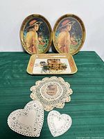 Group shot of three Coca-Cola trays and assorted doilies