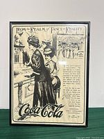 Front view of framed Coca-Cola advertisement poster