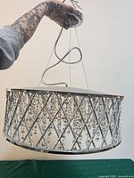 Side view of chrome drum chandelier showing lattice frame and crystal beads