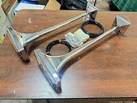Pair of chrome rectangular air horns with tubing and hardware on table
