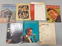 Front covers of seven Johnny Cash songbooks displayed