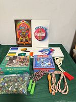 Group shot of all items—prints, puzzle box, tin, marbles, jump ropes