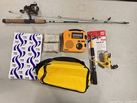 All items laid out: two rod/reel combos, cooler, radio, ice pack, blankets