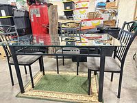 glass top table with two chairs visible