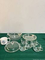 All items overview: casserole with lid, extra lid, two pie plates, five glass mugs, ceramic mug
