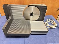 Front view showing food carriage, stainless blade, attached cord