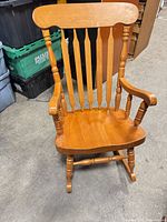 Front view of rocking chair showing spindle back, armrests, seat and legs