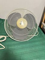 Front view showing grill, logo, blades, cord