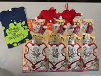 Group shot showing 4 packaged sword/shield sets, 2 plush hearts, and graphic T-shirt