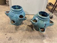 Pair of turquoise ceramic strawberry planters side-by-side