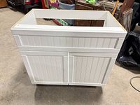 Front view of white beadboard vanity base cabinet showing two doors and Shaker styling