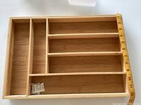 Top view of bamboo drawer organizer with measuring tape showing length