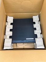 Player seated in protective corner inserts inside cardboard box