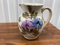 Full view of pitcher showing floral design, handle, spout