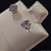 Front view showing tanzanite studs in gold setting on display card
