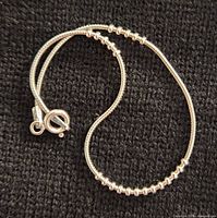 Full view of sterling silver snake-chain bracelet with beads and clasp