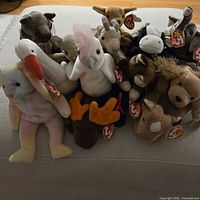 Group of 14 Ty Beanie Babies piled together showing tags and overall condition