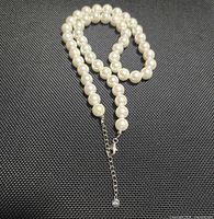 Necklace coiled showing pearls, extender, clasp