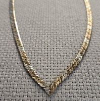 Close view of V-shaped front showing two-tone flat chain detail