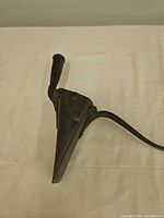 Side view showing conical funnel, wooden grip handle and curved rear handle