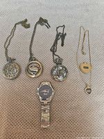 All six watches laid out showing exterior designs and chains
