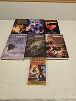 Seven novels laid out to show fronts, sizes and mix of hardcovers and paperbacks