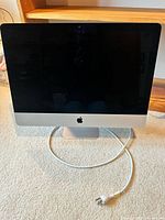 Front view of Apple iMac with screen and power cord