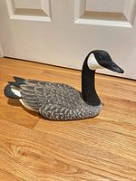 Full view of carved Canada Goose decoy on wooden floor