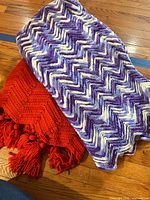 Both folded blankets showing colors and crochet patterns