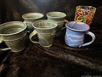 Group shot of four blue-green mugs, blue speckled mug, Confetti tumbler